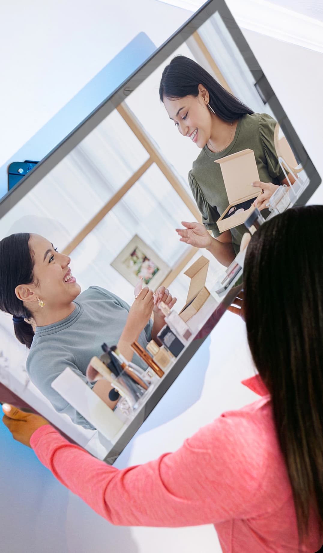 roflect-tv-mirror-01 Woman positioning a Roflect mirror TV screen showing two women showing various beauty products.